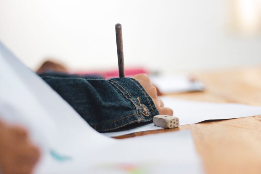 Close-up of a child's hand drawing on paper, focusing on creativity and education.